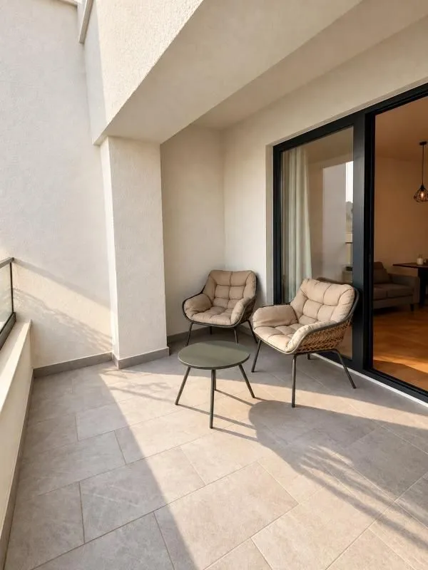 Covered terrace furnished with two armchairs and a small table.