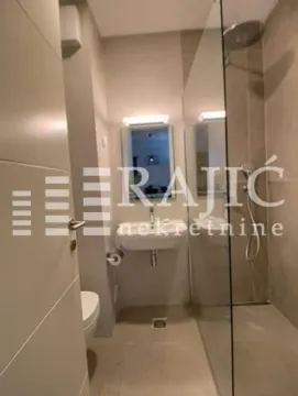 Modernly equipped bathroom with a walk-in shower. - image 11