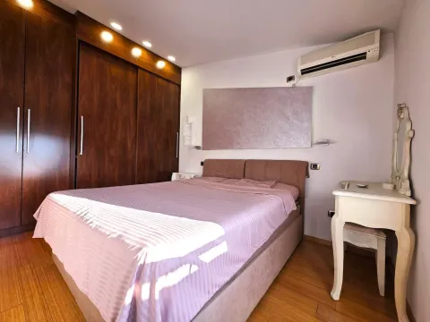 Furnished bedroom with a large double bed, wooden wardrobe, and air conditioning. - image 16