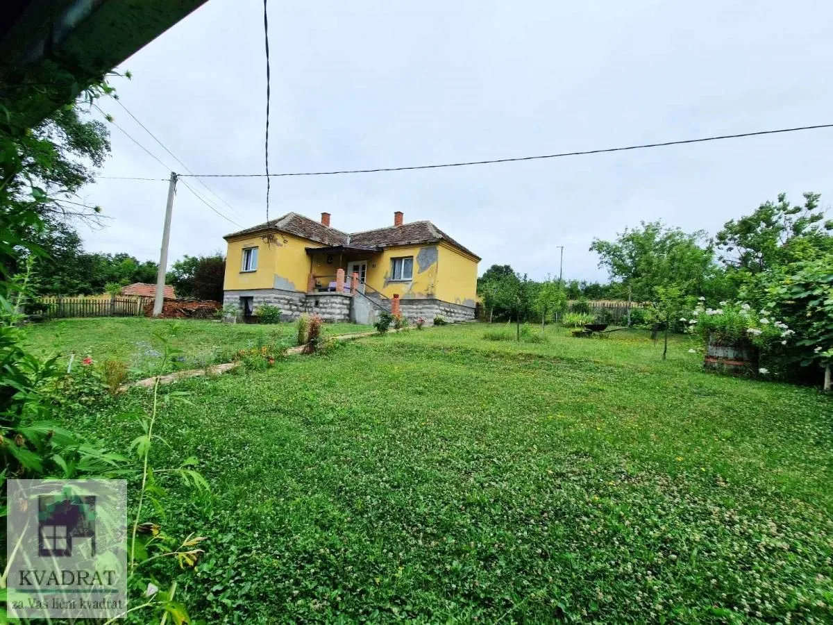 Pogled na dvorište i fasadu kuće sa zelenom travom.