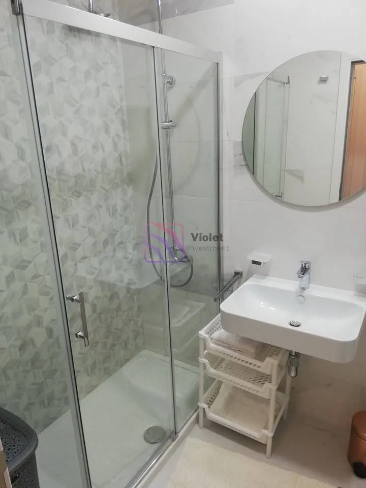 Modernly equipped bathroom with a shower cabin and a sink.