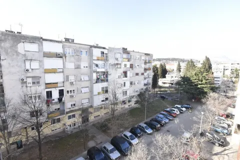 View of a multi-story residential building and the parking lot in front. - image 4