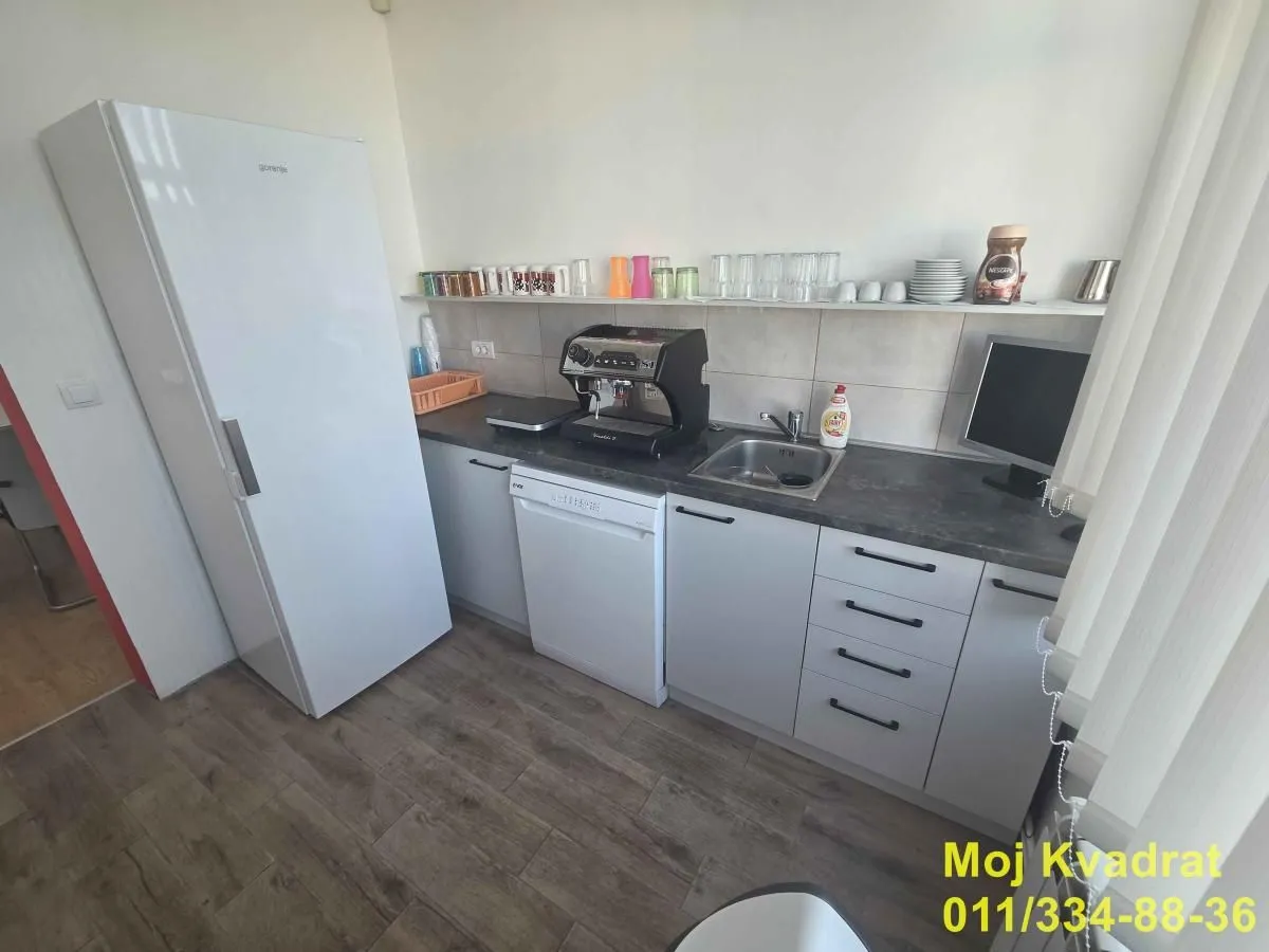 Small kitchen with white cabinets, refrigerator, and sink.