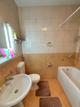Jednostavno kupatilo sa kadom, lavaboom i keramičkim pločicama u toplim tonovima. - image 7