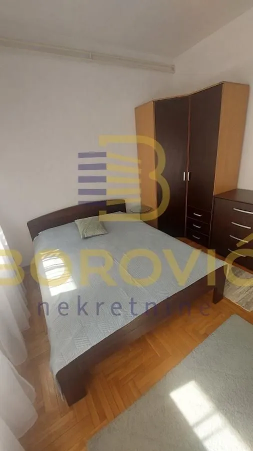 Spavaća soba sa bračnim krevetom i ormarom.