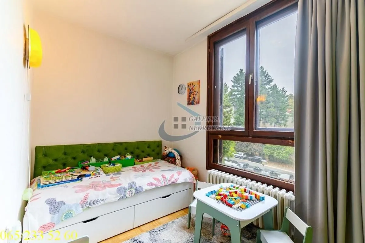 Children's bedroom with a bed and a window overlooking the street.