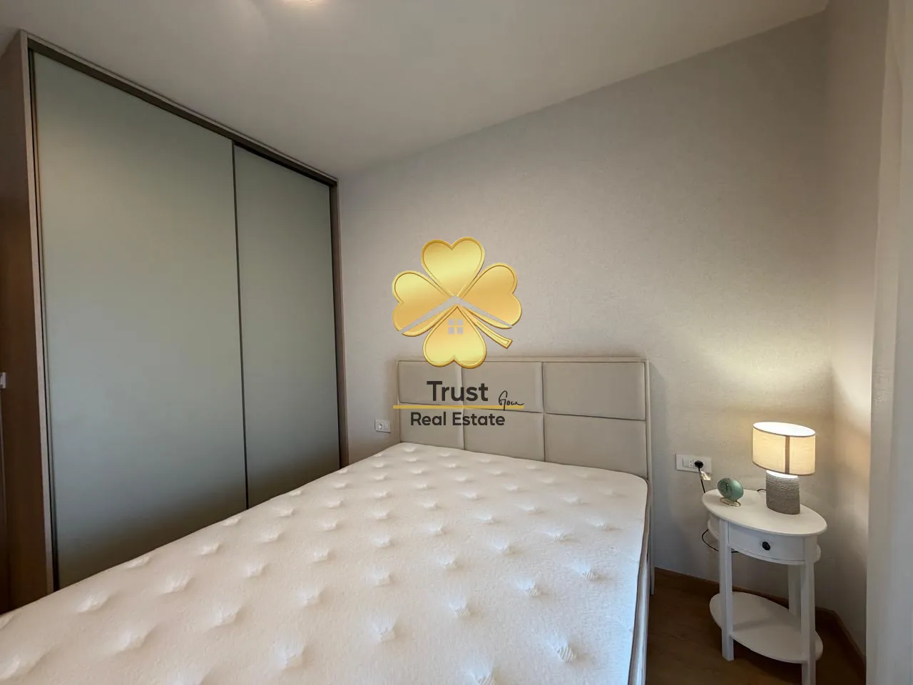 Modern bedroom with a double bed, wardrobe, and a nightstand.
