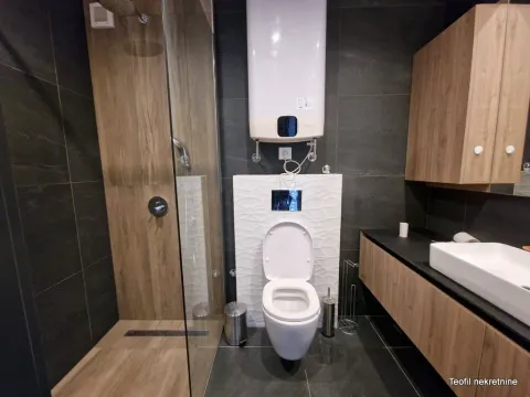 Moderno opremljeno kupatilo sa tuš kabinom, konzolnom šoljom i umivaonikom. - image 14