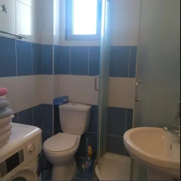 Kupatilo sa tuš kabinom, veš mašinom i plavo-bijelim pločicama. - image 5