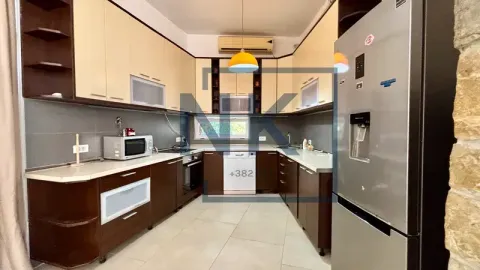 Equipped kitchen with wooden cabinetry and appliances. - image 9
