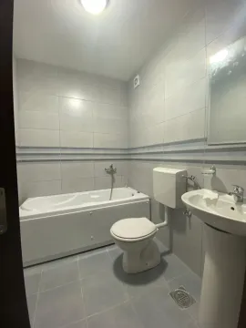 Kompaktno kupatilo sa kadom, umivaonikom i toaletom u svijetlim pločicama. - image 7