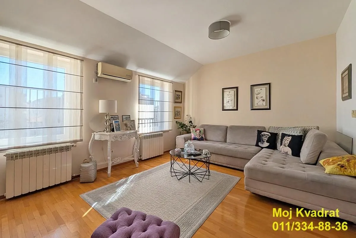 Living room with sofa, coffee table, and windows.