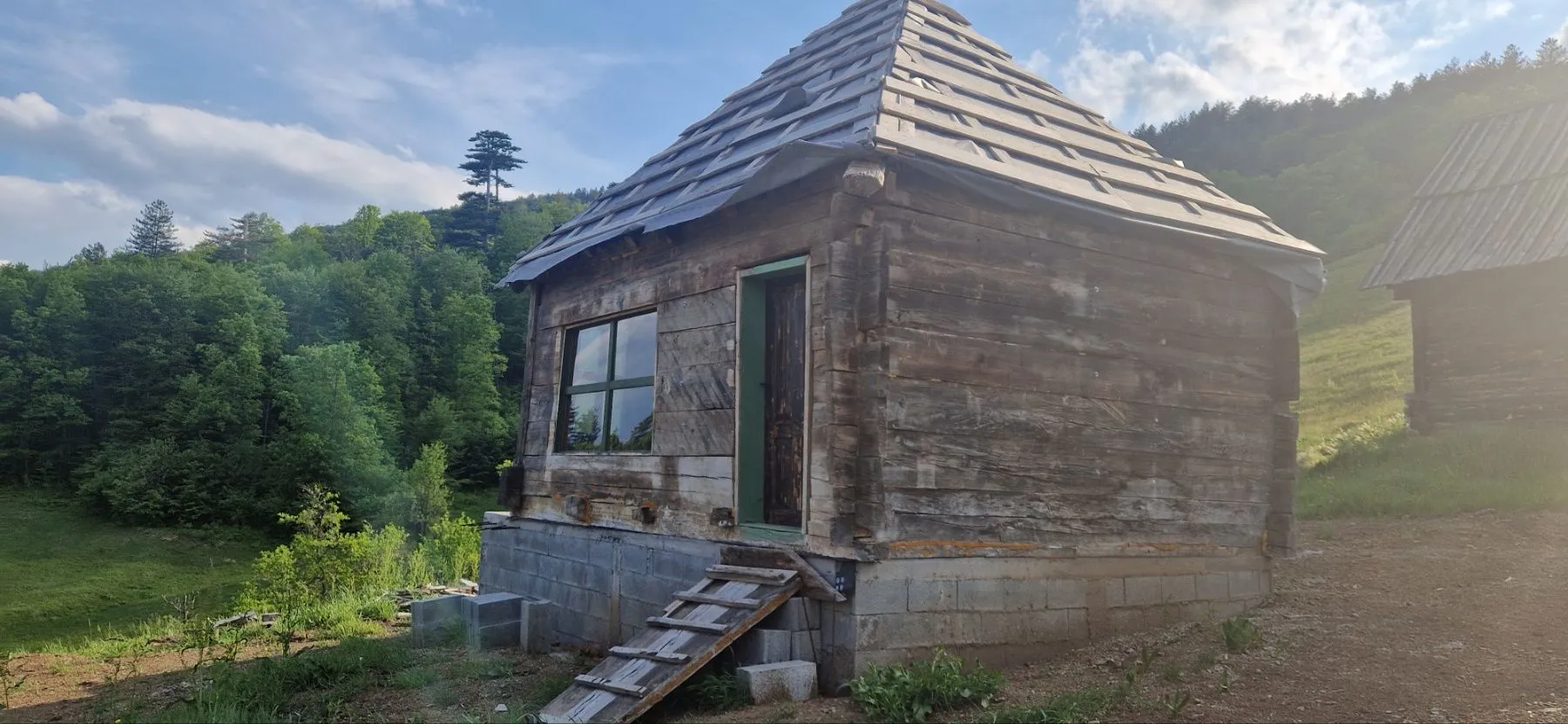 Mala drvena kuća u izgradnji okružena prirodom.