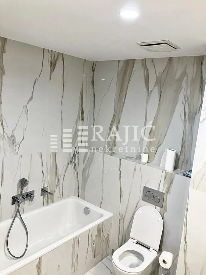 Modernly equipped bathroom with a bathtub and toilet.