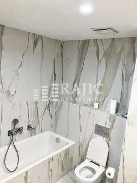 Modernly equipped bathroom with a bathtub and toilet. - image 12