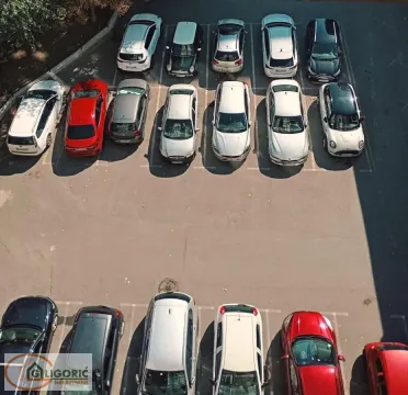 Pogled iz vazduha na parking prostor sa označenim parking mestima i parkiranim automobilima. - image 20