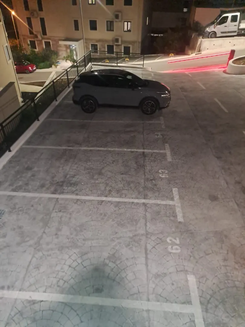 Elevated view of the parking area in front of an apartment building at night.