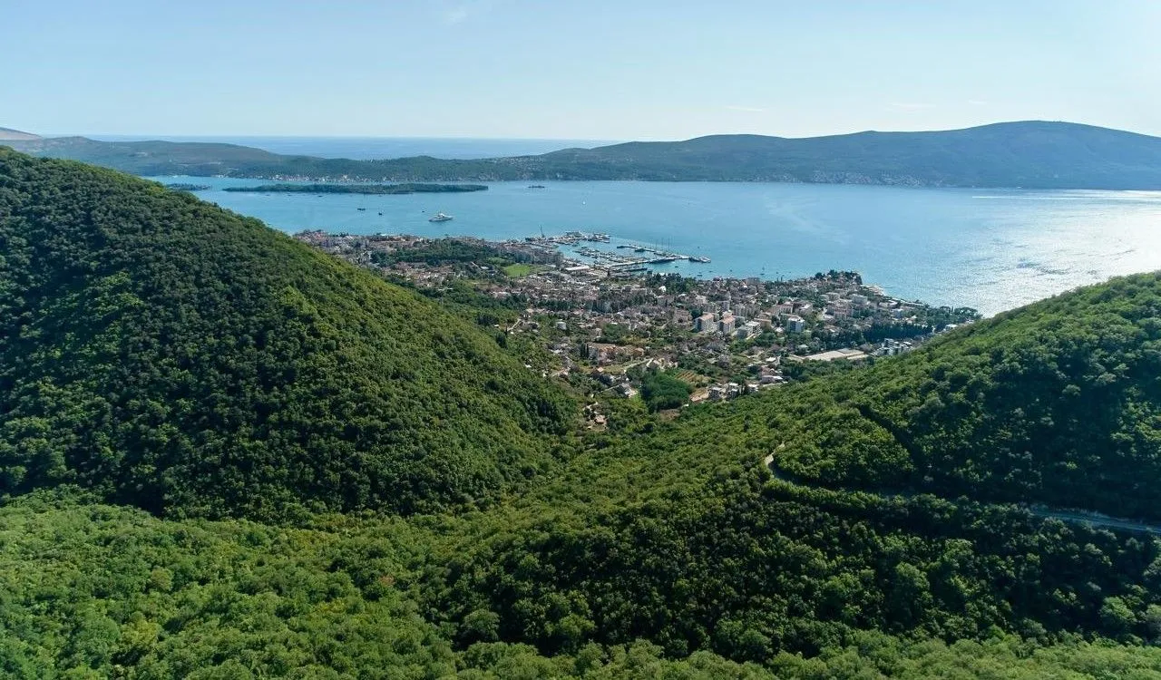 Pogled iz vazduha na zaliv i okolne zelene brežuljke.