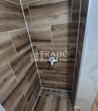 Prikaz tuš kabine obložene pločicama sa dezenom drveta. - image 13