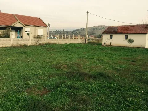 Travnato dvorište sa kućom i pomoćnim objektom u pozadini. - image 3