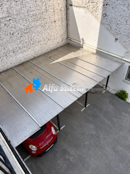 Covered parking space with a parked car in the yard.