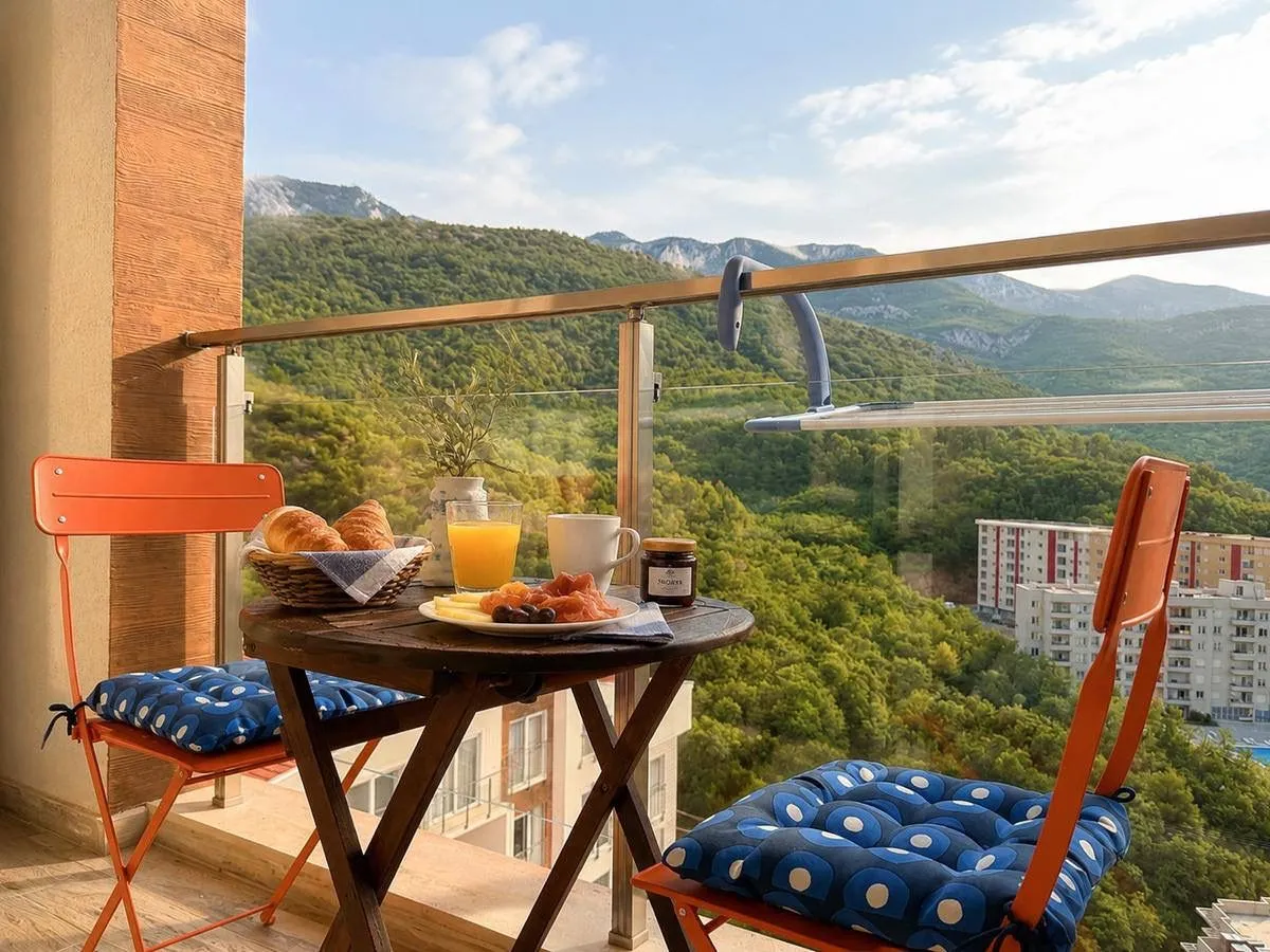Furnished balcony with a table, chairs, and a mountain view.