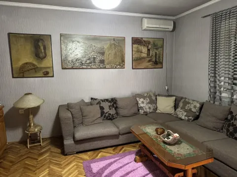 Dnevna soba sa velikom ugaonom garniturom, klub stolom i umjetničkim slikama na zidu. - image 22