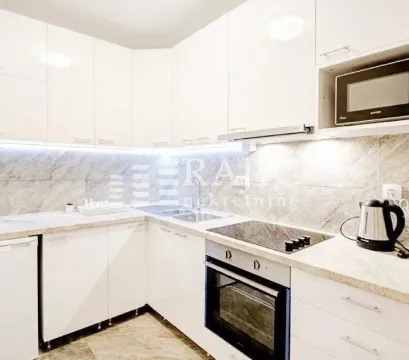 Modern white kitchen with built-in oven, cooktop, and microwave. - image 11