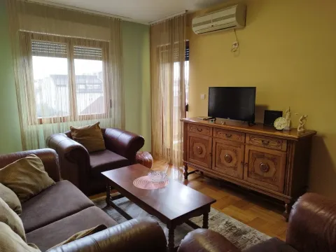 Bright living room with leather furniture, a wooden sideboard, and a TV. - image 2