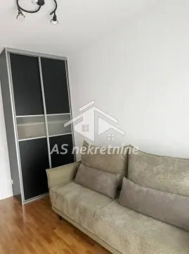Dnevna soba sa bež kaučem i crnim ugradnim ormarom. - image 16