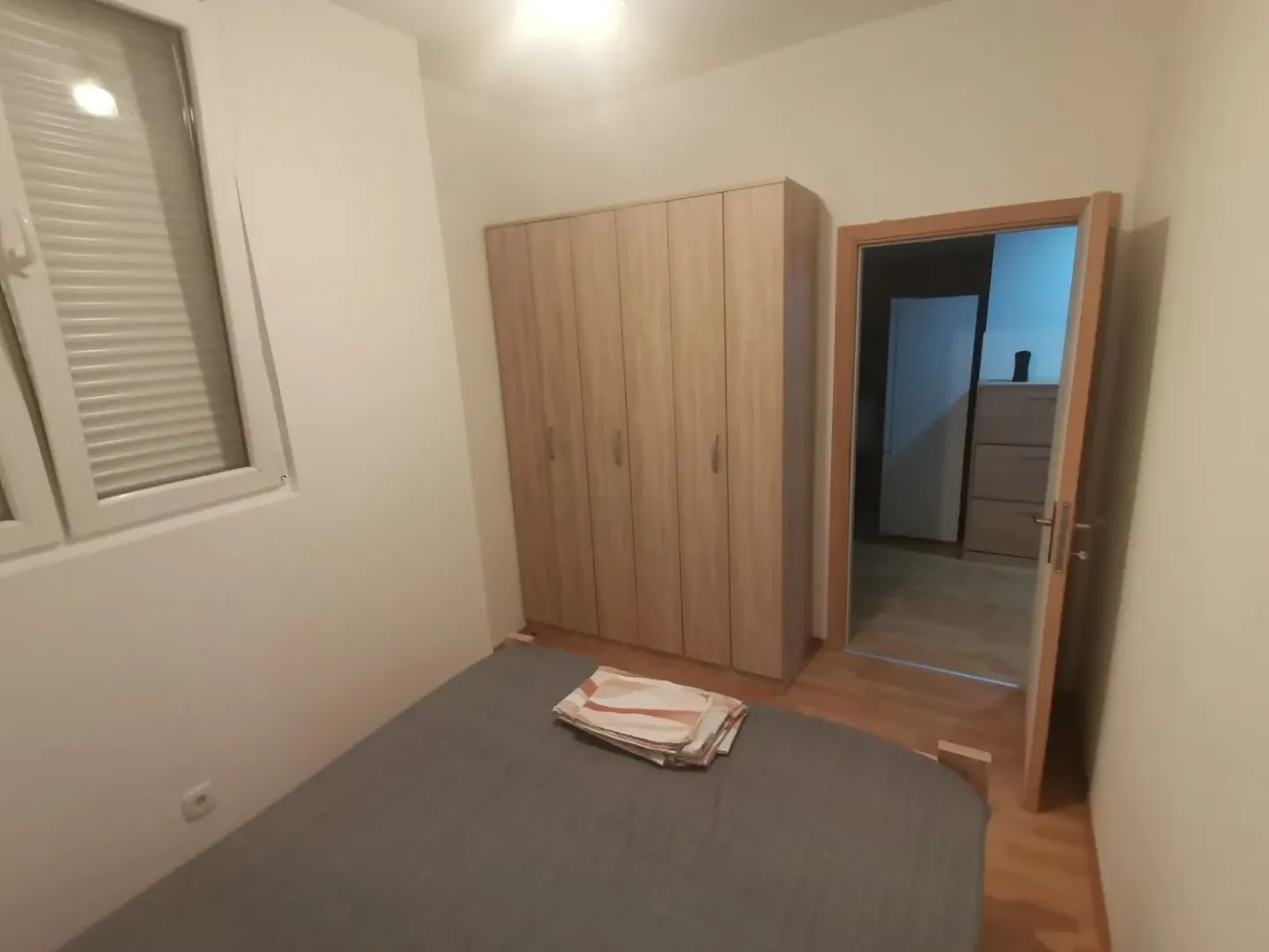 Simply furnished bedroom with a wardrobe.