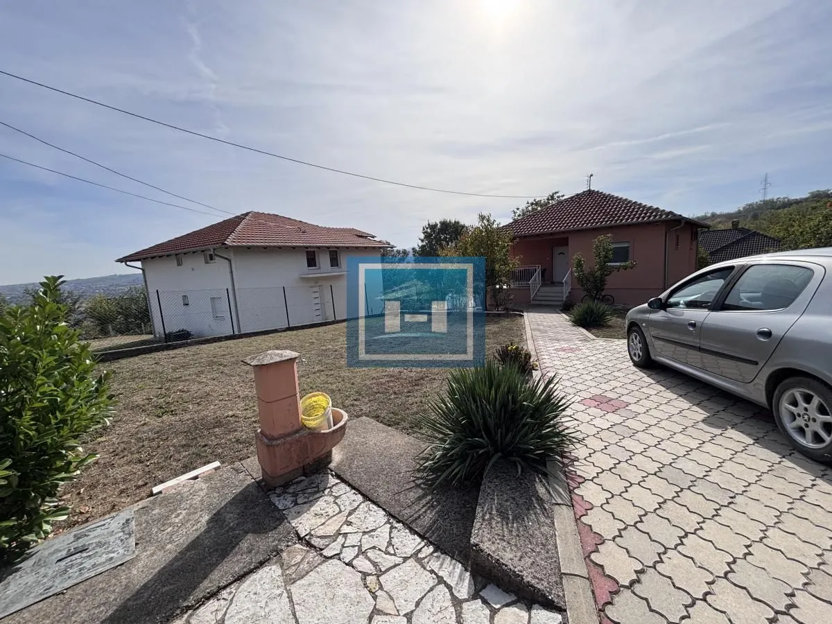 Pogled na dvorište i kuću sa popločanom stazom.