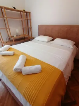 A bedroom with a double bed and a wooden shelf. - image 5