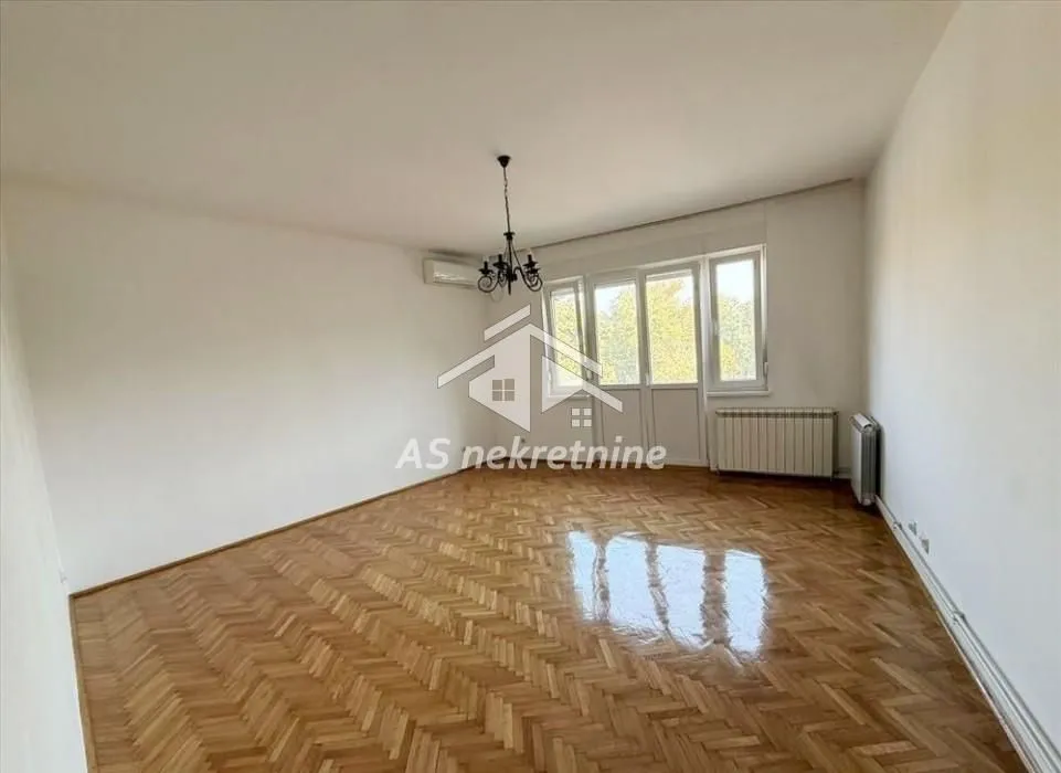 Empty living room with parquet flooring and access to the terrace.