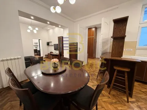 Prostrana trpezarija sa drvenim stolom i stolicama, povezana sa dnevnim boravkom. - image 8