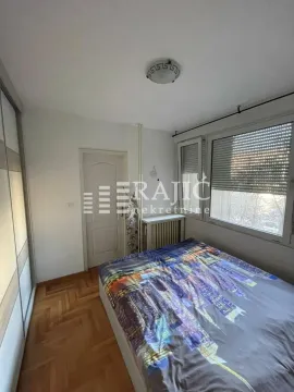 Furnished bedroom with a double bed, wardrobe, and windows. - image 9