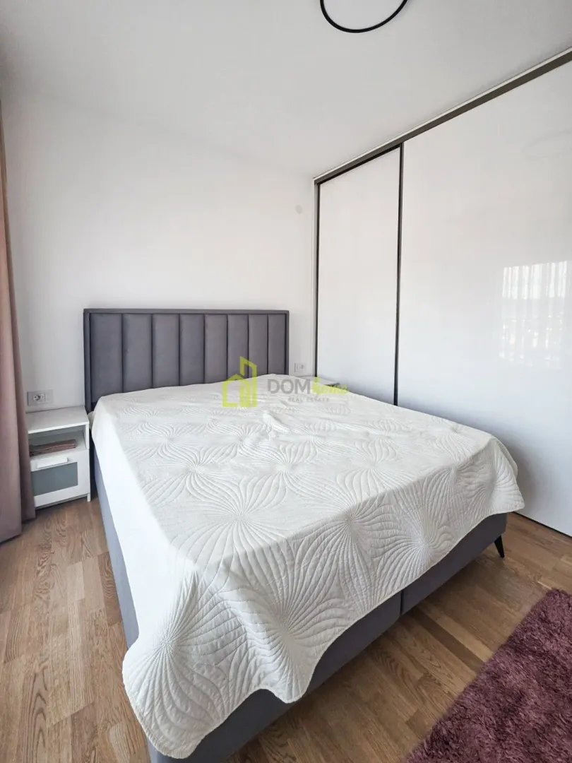 Spavaća soba sa bračnim krevetom i ugradnim ormarom.