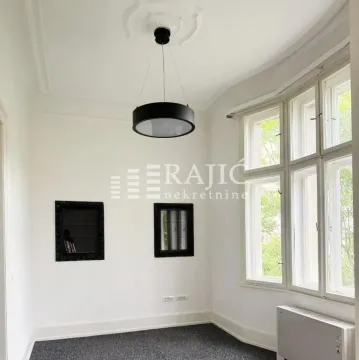 Empty room with large windows and a black chandelier. - image 4