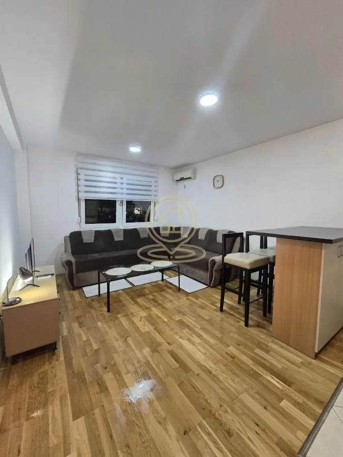 Dnevna soba sa ugaonom garniturom, stočićem i šankom.