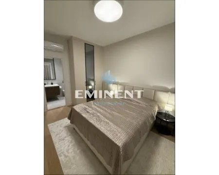 Furnished bedroom with a double bed, wardrobe, and a view into the bathroom. - image 7