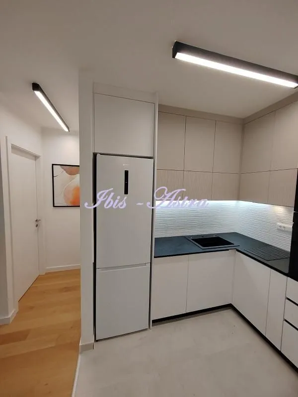 Modern kitchen with built-in appliances and a refrigerator.