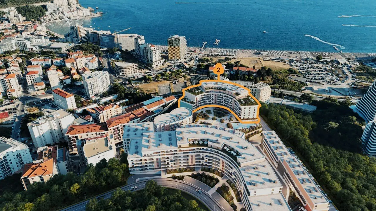 Pogled iz vazduha na stambeni kompleks blizu obale sa označenom zgradom.