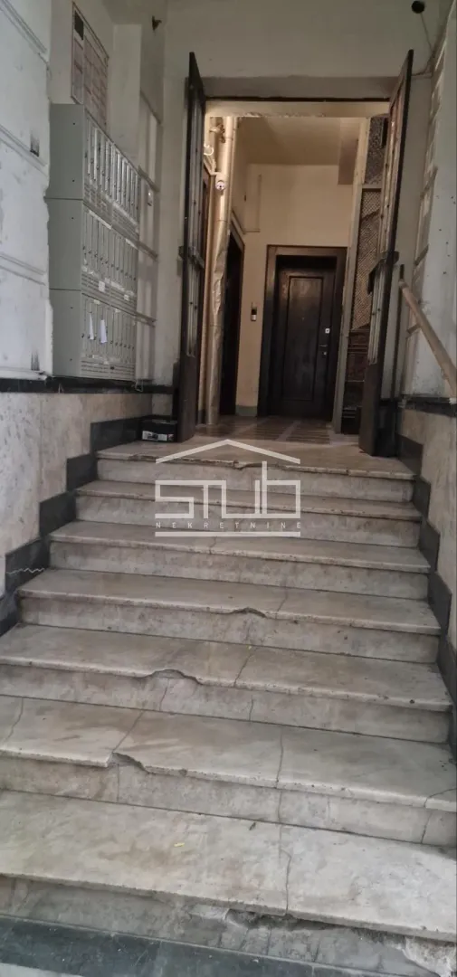 Building entrance with marble stairs and mailboxes.