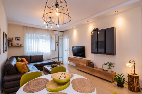 Living room with a sectional sofa, dining table, and TV unit. - image 4