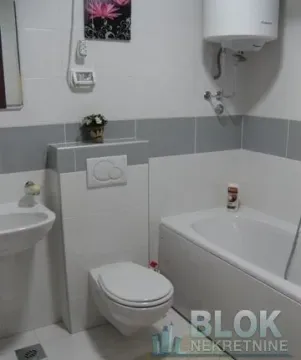 Compact bathroom with a bathtub, washbasin, and a wall-hung toilet. - image 8