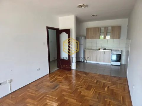 Living room with parquet flooring and kitchen in the background. - image 4