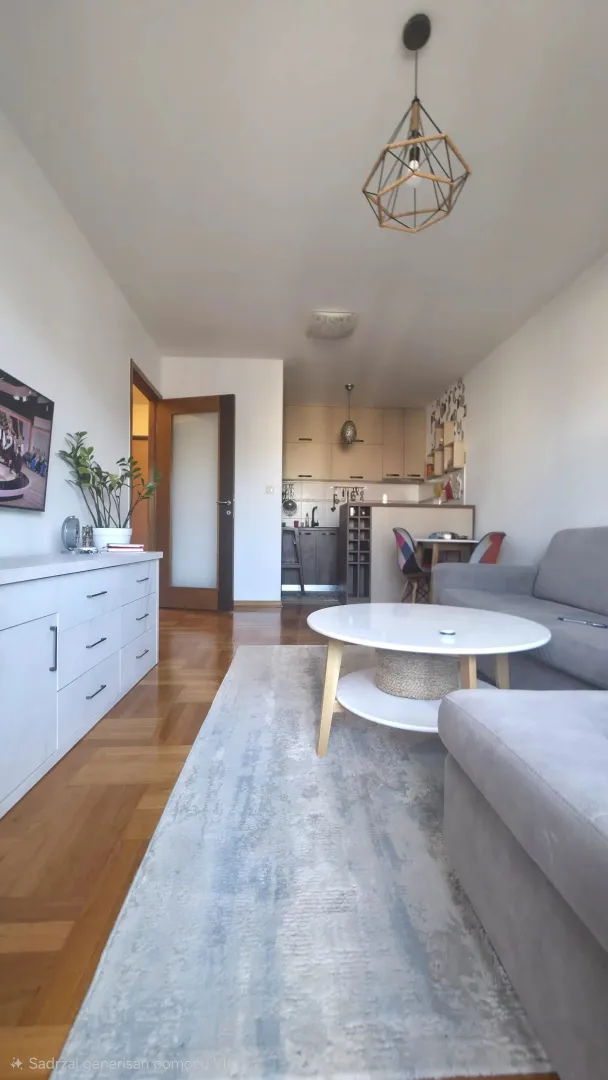 Living room with a sofa, coffee table and a view of the kitchen.