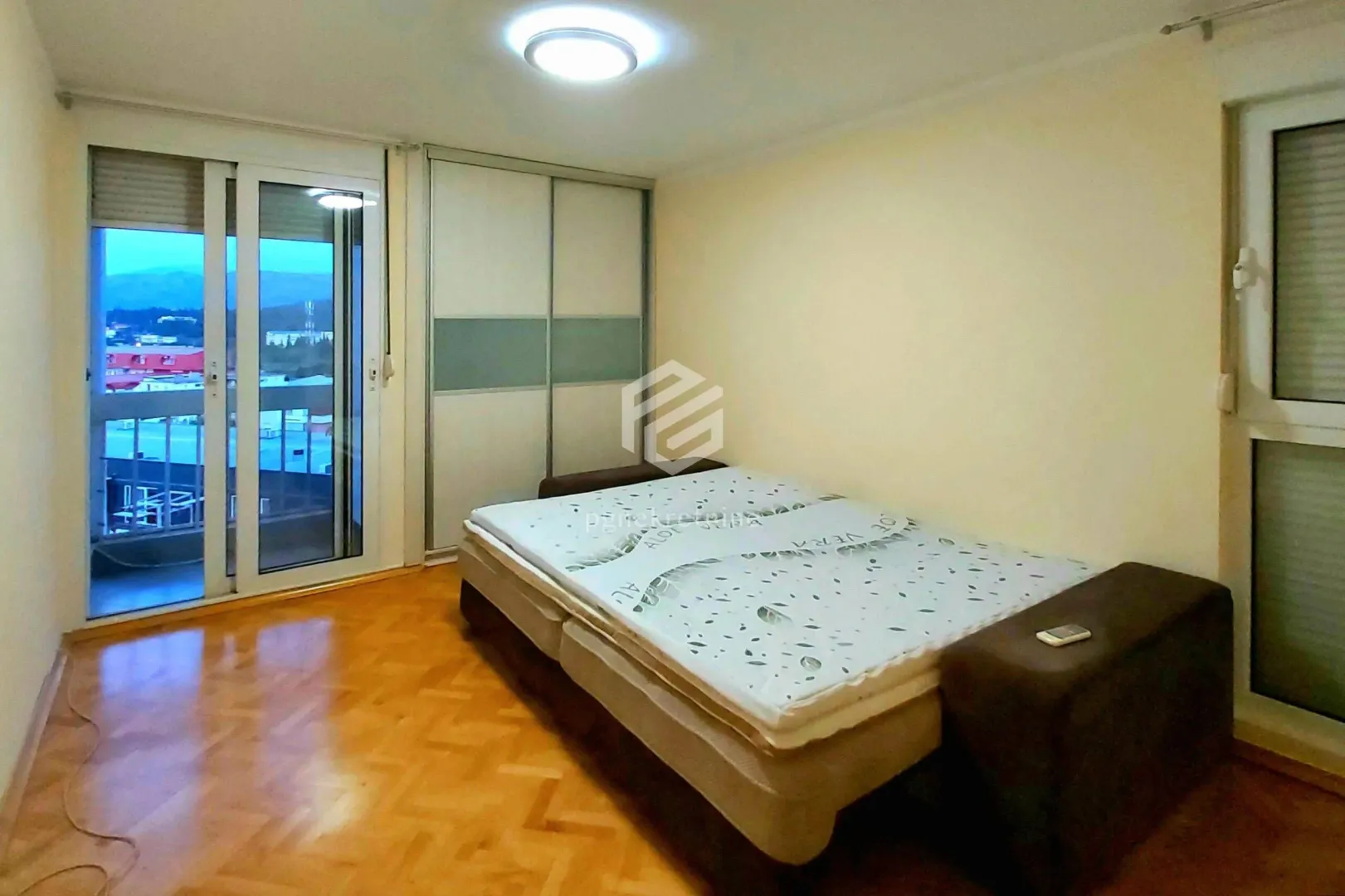 Bedroom with a double bed, wardrobe, and access to the terrace.