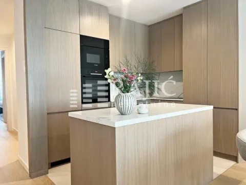 Modern kitchen with wooden cabinetry, an island, and a built-in oven. - image 8