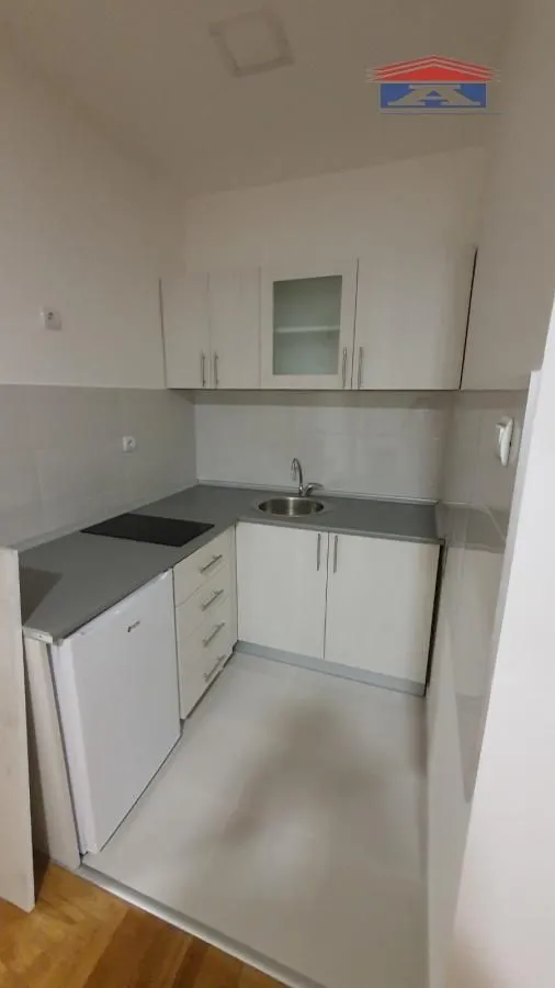 Small kitchen with white cabinets and a sink.